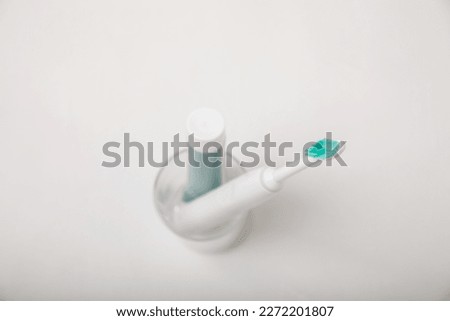 Electronic ultrasonic toothbrush and toothpaste on texture background. Items for dental care and caries prevention in the bathroom. Dentistry concept. Copy space.