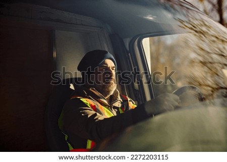 Professional truck driver on the road. The view is through the windshield.  Royalty-Free Stock Photo #2272203115