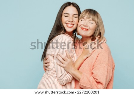 Adorable lovely fun satisfied elder parent mom with young adult daughter two women together wearing casual clothes hugging cuddle close eyes isolated on plain blue cyan background. Family day concept Royalty-Free Stock Photo #2272203201