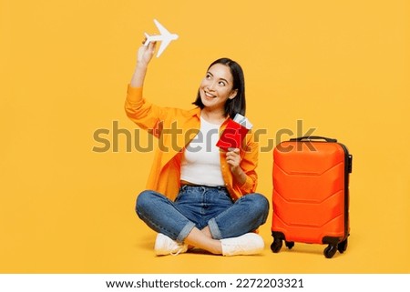 Young woman wear summer casual clothes hold passport ticket airplane mockup isolated on plain yellow background. Tourist travel abroad in free spare time rest getaway. Air flight trip journey concept Royalty-Free Stock Photo #2272203321