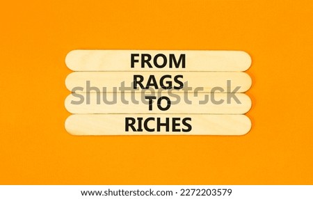 Rags or riches symbol. Concept words From rags to riches on wooden stick. Beautiful orange table orange background. Business rags or riches concept. Copy space.