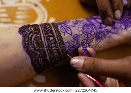 Applying Beautiful henna art on hands. Bridal design. Wedding Mehendi. Indian arabian culture of wedding mehendi Drawing process of henna menhdi ornament on woman's hand hands of a tourist in henna