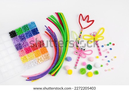 Beaded Pipe Cleaner flowers and dragonflies. Easy spring kids crafts. Different multi-colored supplies and materials for DIY art activity for kids. Children's crafts, creativity and  hobby.  Royalty-Free Stock Photo #2272205403