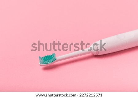 Electronic ultrasonic toothbrush on a pink background.Smart electric toothbrush. Items for dental care and caries prevention. Dentistry concept. Modern technologies for health. Healthy teeth.