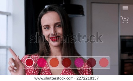 A beautiful woman chooses a lipstick color in a virtual store menu with augmented reality. She presses a color picker button on a smart touch web screen.