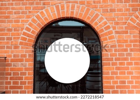 Mockup round lightbox. White blank circle space frame on orange brick wall background. Wall signage logo mockup whit blank screen. High quality photo