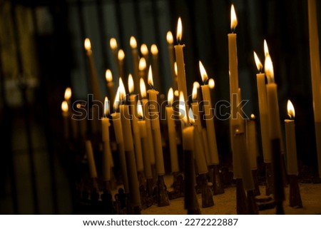 burning candles in dark church and beautiful blurred background