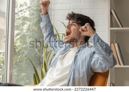 young teenager at home elated celebrating Royalty-Free Stock Photo #2272226447