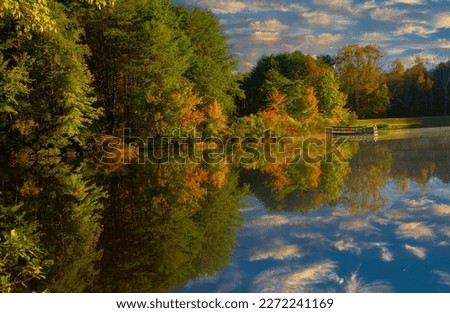 Shorts Lake is surrounded by hardwood trees showing fall color, in Crowders Mountain State park, North Royalty-Free Stock Photo #2272241169