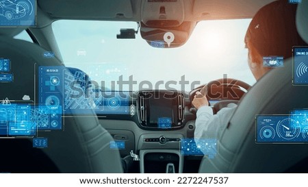 Woman driving a car and automotive technology concept. Driver assistant system. ITS (Intelligent Transport Systems). Mobility as a service. Royalty-Free Stock Photo #2272247537