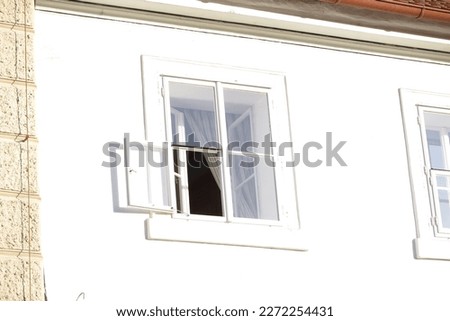 The window with a white frame on the white wall