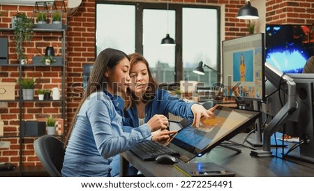 Female content creators editing professional images with retouching software and stylus pen, working on multimedia content. Diverse graphic artists processing photos using tablet and touchscreen.