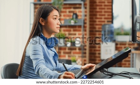 Female graphic designer editing photos with tablet and stylus, using retouching software for pictures post production. Young editor working on multimedia content with skills. Close up.