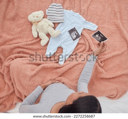 Pregnant, baby clothes and mother with scan, x ray and teddy bear in bed of kid, infant and child. Pregnancy love, family home and top view of excited and happy woman with prenatal picture in bedroom