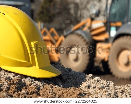 Hard hat on the construction site excavator on the background