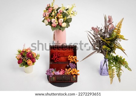 Roses, plants, and other flowers in pots and vases, a wooden box with berries on a white isolated background. Copy space. botanical or gardening concept.