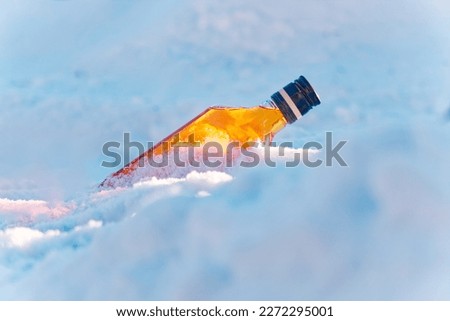 Beautiful sunrise on a cold snow dune, accompanied by a bottle of whiskey. The high-quality image adds a touch of calm and majesty to your creative project, perfect for evoking the serenity of nature.