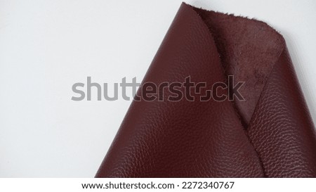 maroon cow leather. with a white background. close up photo of cowhide. backgrounds, textures.