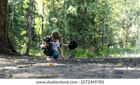 a boy with a metal detector is looking for treasure in the forest. High quality photo