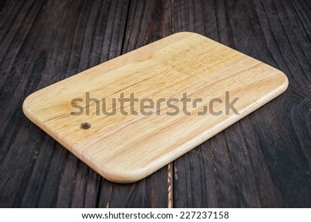 Cutting board on wooden background - old style picture process