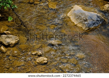 shallow river water with rocks around it, picture taken from an angle above during the day Royalty-Free Stock Photo #2272374465
