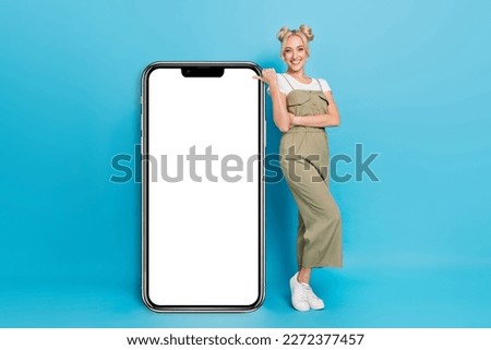 Full size photo of optimistic blond lady show placard wear t-shirt overall footwear isolated on blue background