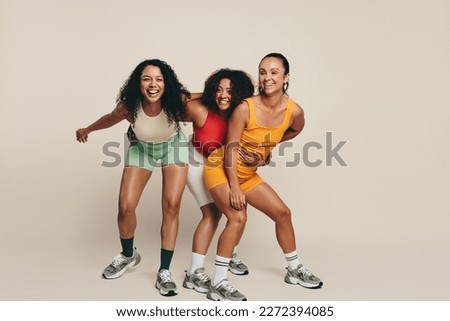 Group of young female athletes laughing and having fun in fitness clothing, celebrating their love for sport and exercise. Happy young sportswomen demonstrating their commitment to a healthy lifestyle Royalty-Free Stock Photo #2272394085