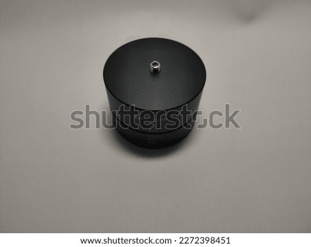 camera accessory, black in color, round in shape, and rotatable, functions as a timer for video capture using the time-lapse technique.