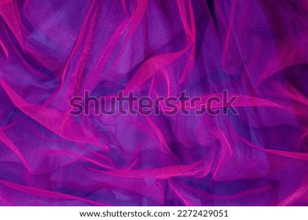 Elegant wallpaper made of vivid pink tulle fabric on purple background. Aesthetic fashion and love design.