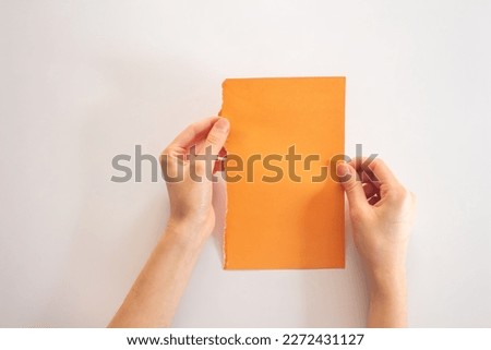Hand holding a blank paper, top view