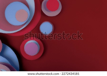 Abstract colored paper circles shapes in red background. Minimalist background. Flat lay. Copy space.