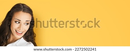 Happy excted smiling woman in white confident cloth looking aside. Business advertisement concept. Brunette businesswoman, isolated orange yellow background. Royalty-Free Stock Photo #2272502241