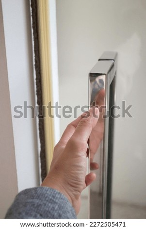 Hand on metal door holder, stock photo