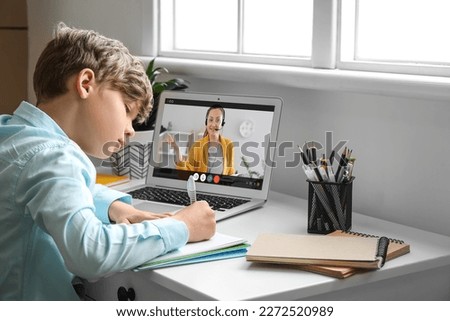 Cute little boy studying online at home