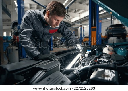 Worker conducts full technical check of auto Royalty-Free Stock Photo #2272525283