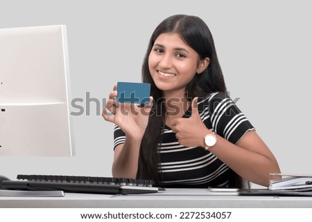 Portraits of young working woman and showing credit card