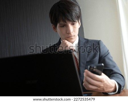 man working with laptop and smartphone