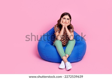 Full body length photo of young stressed sit bean bag unhappy minded bored woman touch cheekbones look empty space isolated on pink color background Royalty-Free Stock Photo #2272539639