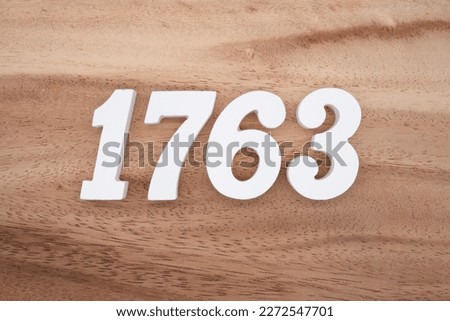 White number 1763 on a brown and light brown wooden background.