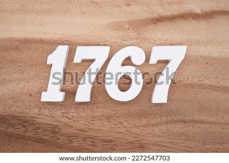 White number 1767 on a brown and light brown wooden background.