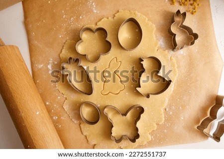 Easter cookie dough and cookie cutters on baking paper close-up. High quality photo