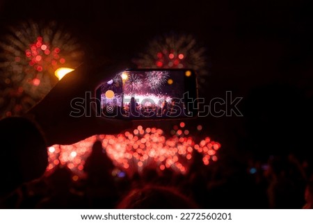 Hand of man taking the photo of fireworks by smartphone