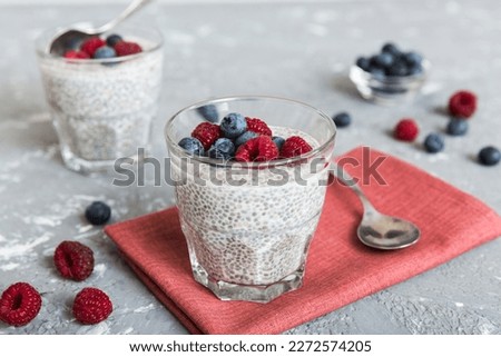 Healthy breakfast or morning with chia seeds vanilla pudding raspberry and blueberry berries on table background, vegetarian food, diet and health concept. Chia pudding with raspberry and blueberry. Royalty-Free Stock Photo #2272574205