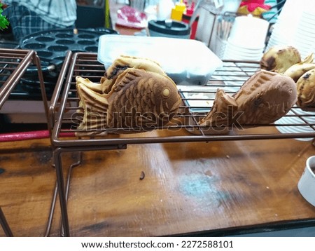 Taiyaki is a traditional Japanese fish-shaped cake.  The top of the cake is baked separately from the bottom of the cake.  After the cakes were almost done, the two were put together with red bean jam