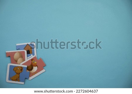 brown dog puzzle, knowledge puzzles with pictures of brown dog, chicken, white egg and kennel placed on the left over blue background.