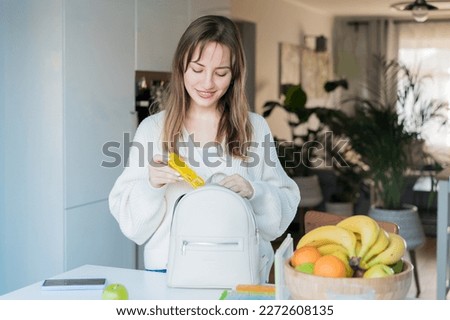 Woman putting daily pills organizer into her bag. Taking daily medicine antioxidant diet vitamin supplements for beauty skin hair health care medicament biohacking concept. Selective focus. Royalty-Free Stock Photo #2272608135