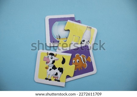 Animal picture puzzles are animal picture puzzles with fish, bell jar, cow and milk mixed up on a blue background.