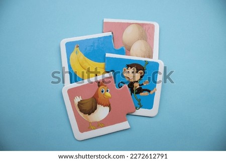 Animal picture puzzles are animal picture puzzles with chicken, egg, banana and monkey images mixed together on a blue background.