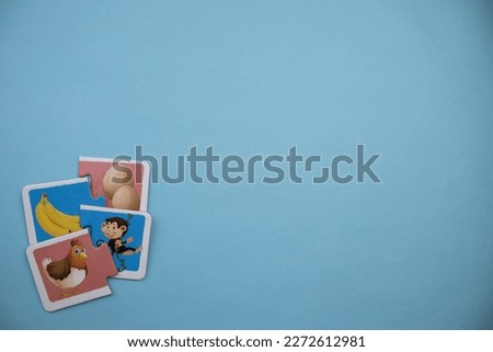 Animal picture puzzles, animal picture puzzles with chicken, egg, banana and monkey pictures mixed on the left of a blue background.