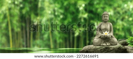 buddha statue on a rock in a blurred green bamboo jungle with smooth water surface, fresh natural spa wallpaper concept with asian spirit and copy space Royalty-Free Stock Photo #2272616691
